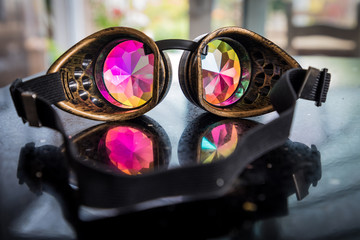 Festival kaleidoscope goggles reflecting on bench - obrazy, fototapety, plakaty