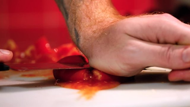 Close-up of hands smashing fresh tomato