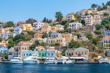 Sail boats, yachts and colorful houses in harbor town of Symi (Symi Island, Greece)