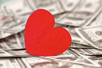 red heart stands on money one hundred dollars