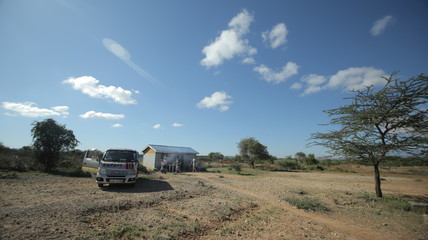Beautiful landscape of the steppe, house in the field and car in Africa.