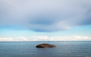 Lonely rock, clouds and a blue sea view in Finland