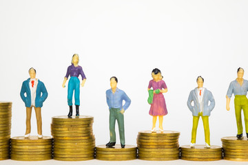 Figure miniature businessman or small people investor and office worker secretary standing on coin stack, for money and financial business success concept.