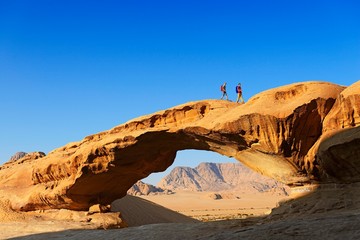 Couple hiking at Rock-Arch named Al Kharza, Wadi Rum, Jordan, Asia
