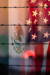 Conflict between USA and Mexico, conceptual image, a barber wire wall with a beautiful sunset, the flag of mexico and usa face to face, political concept for the borders' wall