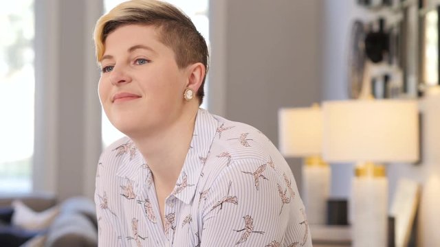 Blonde woman sips coffee in bright, clean, modern kitchen