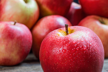 Fresh organic ripe red apples with water drops on wooden background, Apple fruit concept