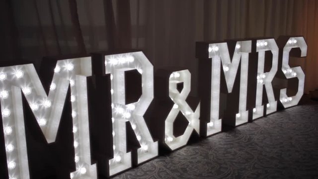 A vertical panning shot from the floor of a  Mr & Mrs box light sign, bold text and lights make a great bold statement at any wedding of event, a great feature for someones special day