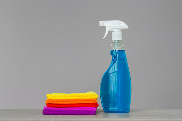 A set of colorful cleaning clothes and a cleaning agent in a spray bottle. Place for text. Concept  spring cleaning.
