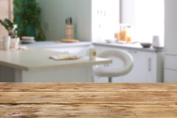 Empty light wooden table in modern kitchen blurred background. Mockup for design