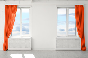 Modern windows with stylish orange curtains indoors