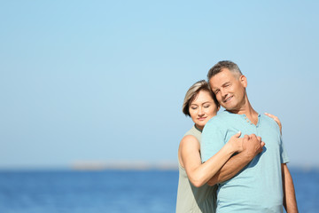 Fototapeta na wymiar Happy mature couple at beach on sunny day