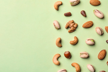 Flat lay composition with organic mixed nuts and space for text on color background - obrazy, fototapety, plakaty