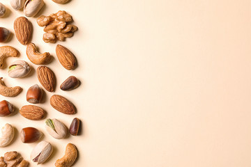 Flat lay composition with organic mixed nuts and space for text on color background