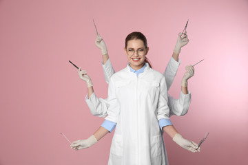 Female dentist with multiple hands holding tools on color background