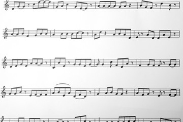 Sheet with music notes as background, top view