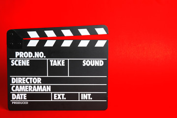 Naklejka premium Clapperboard on color background, space for text. Cinema production