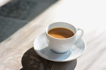 Coffee in white cup on the floor in the morning . 