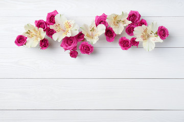 Fresh flowers on wooden background, top view with space for text