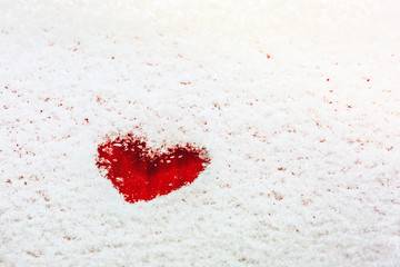 Heart painted on the snow-covered windshield of a car. Copy space.