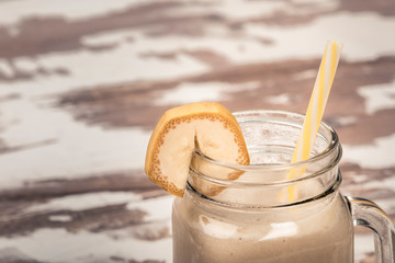 From above tasty fresh drink in glass mug with plastic tube and slice of fruit on coaster on wood table 