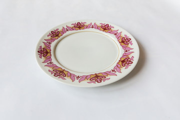 a white round plate with floral and line pattern on white background