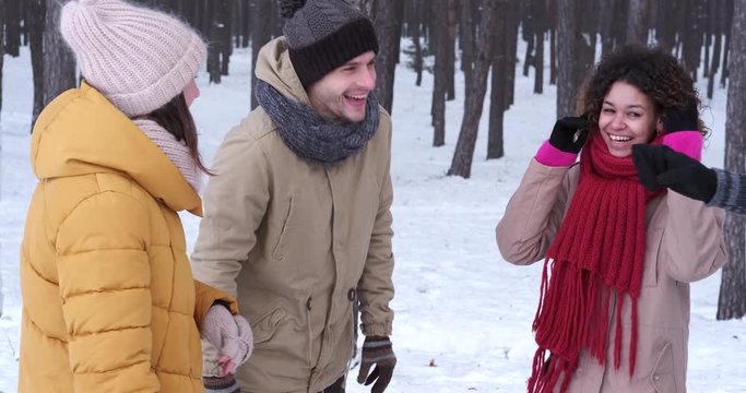 Group of happy young friends enjoying and giving high five in snow