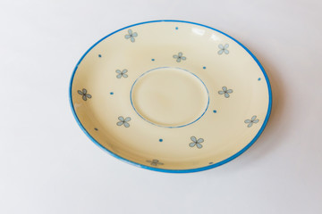 a yellow round plate with floral and line pattern on white background