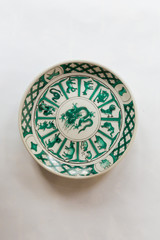 a white round plate with floral and line pattern on white background