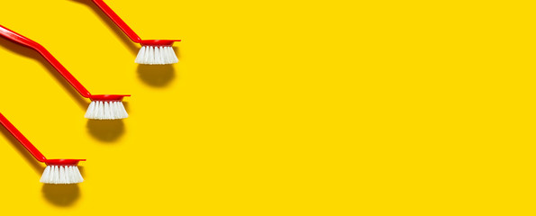 Three red brush lies on a bright yellow background. In the style of pop art. Top view. Copy space.