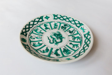 a white round plate with floral and line pattern on white background