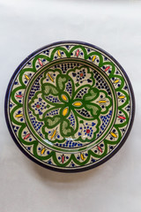 a white round plate with floral and line pattern on white background