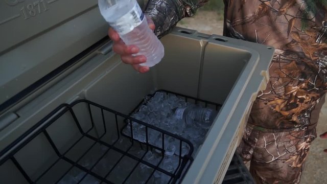 a man getting a drink out of a cooler
