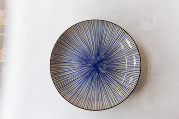 a blue round plate with  line pattern on white background