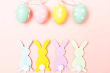 Easter bunnies and eggs on pastel pink background