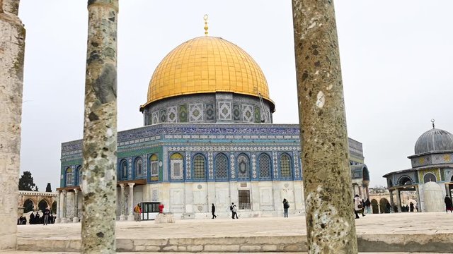 Stunning view of the beautiful Dome of the Rock with tourists taking pictures and strolling around it. The Dome of the Rock is an Islamic shrine located on the Temple Mount in Jerusalem, Israel.