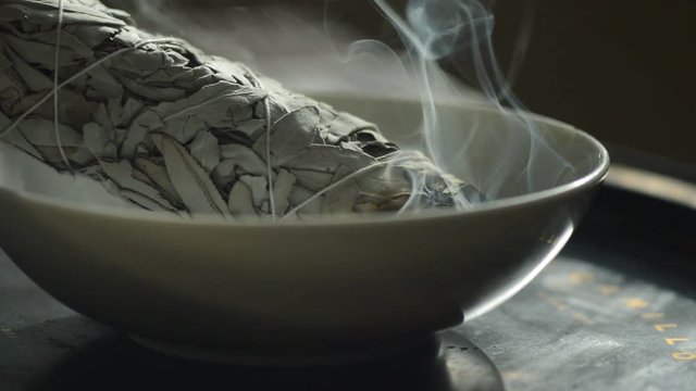 Ceremonial white sage burning in a bowl.