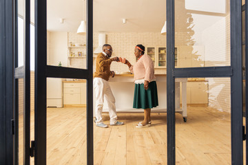 Joyful happy couple drinking tea in the kitchen