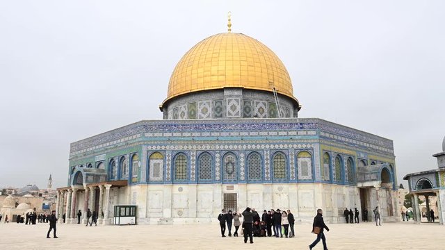 Stunning view of the beautiful Dome of the Rock with tourists taking pictures and strolling around it. The Dome of the Rock is an Islamic shrine located on the Temple Mount in Jerusalem, Israel.
