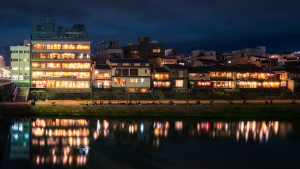 Fototapeta premium Promenade at night along Kamo River next to Shijoo Bridge in Gion District, Kyoto, Japan.