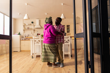 Happy joyful nice couple dancing at home