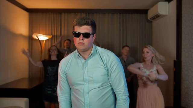 Cheerful nerd male with glasses dancing and partying.