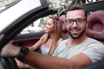 close up.stylish man with his girlfriend traveling in a convertible car.