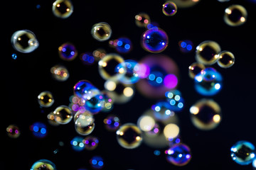 colorful soap bubbles floating in the dark.