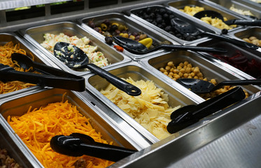 variety of colorful fresh vegetable salad in container in restaurant