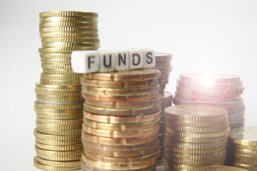 Coins and FUNDs word on white. Business and saving concept.Blurred image.