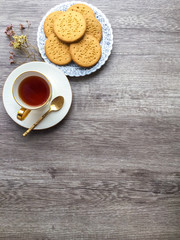 White ceramic cup of tea vintage plate of digestive biscuit cookies on wooden floor background with copy space