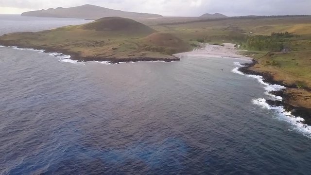 Aerial drone footage Anakena Beach an amazing, idyllic and wild beach in the Pacific Ocean at Easter Island an amazing travel destination with the Moais mystery like Ahu Nau Nau in Anakena beach 1/4