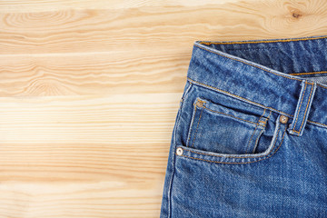 Blue jeans on wooden background.