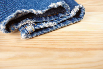 Fototapeta na wymiar Blue jeans on wooden background.
